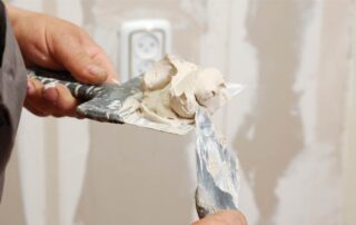 This image shows a man preparing a wall putty.