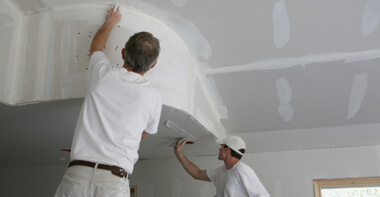 This image shows 2 men fixing a ceiling