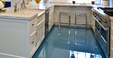 This image shows a kitchen with a blue epoxy floor.
